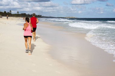 Bir adam ve bir kadın oyun spor çalıştırmak okyanusun üzerinde plaj, Punta Cana, Dominik Cumhuriyeti bir güneşli yaz günü sabahın erken saatlerinde.