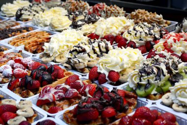 Geleneksel lezzetli, tatlı ve hoş kokulu Belçika Waffle çilek, kivi ve muz, çikolata ve çırpılmış kremalı Brüksel'deki bir vitrin dekore edilmiş.