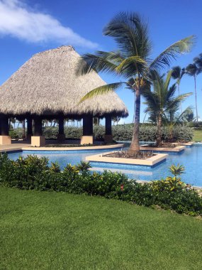 Güzel manzara mavi su havuzu, bungalovlar ve palmiye ağaçları hotel resort Punta Cana, Dominik Cumhuriyeti