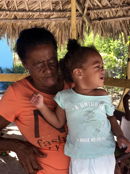 Saona, Dominicana, Aralık 2018. Dominik aile: Büyükanne ve kirli siyah kız evinin bahçesinde bir balıkçı köyü.