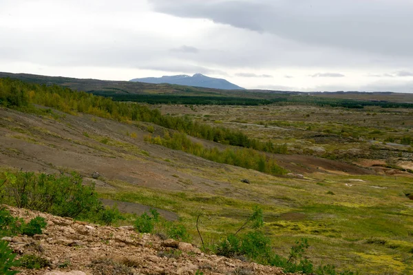 Haukadalur, İzlanda Vadisi'nin görünümü. Güzel güzel manzara: dağlar, bitkiler, bulutlu bir sonbahar günü tepelerde.