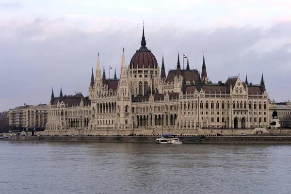 The building of the Hungarian Parliament on the banks of the Danube in Budapest is the main attraction of the Hungarian capital. Beautiful building against the gray sky.