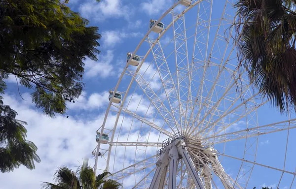 Wheel of review against blue sky with clouds. Attraction. Beautiful Spanish city of Malaga.