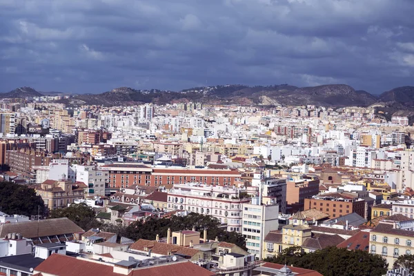 View of the Spanish city of Malaga from a height. Residential buildings, mountains, sights on the background of a cloudy sky. — Stock Photo, Image