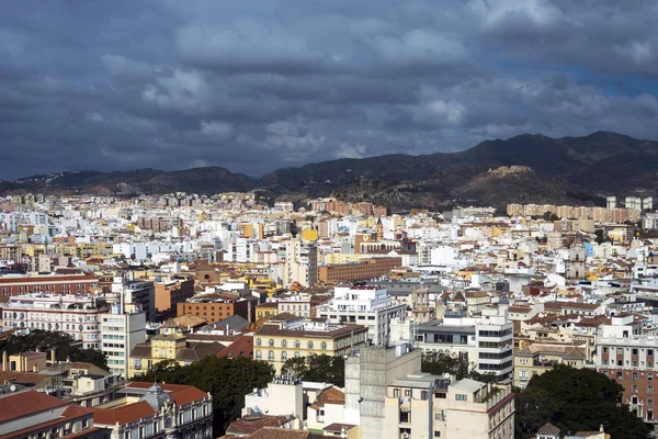 View of the Spanish city of Malaga from a height. Residential buildings, mountains, sights on the background of a cloudy sky. — Stock Photo, Image