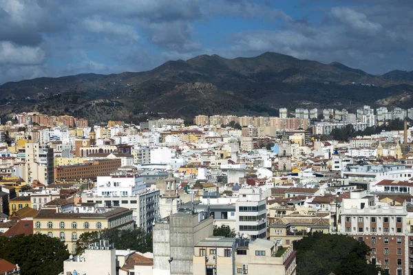View of the Spanish city of Malaga from a height. Residential buildings, mountains, sights on the background of a cloudy sky. — Stock Photo, Image