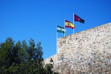 Üç bayrak: İspanya, Andolusia ve Malaga kale savunma duvarına. Arap Kalesi Gibralfaro (İspanyolca. Castillo de Jibralfaro). Harabe.