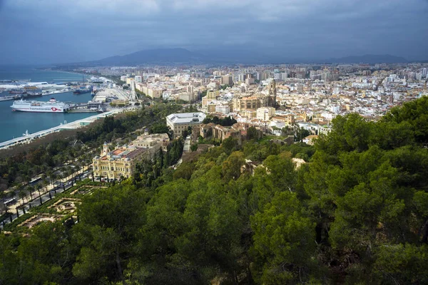 Malaga, Spain, February 2019. Panorama of the Spanish city of Malaga. Buildings, port, bay, ships and mountains against a cloudy sky. Dramatic sky over the city. Beautiful view. — Stock Photo, Image