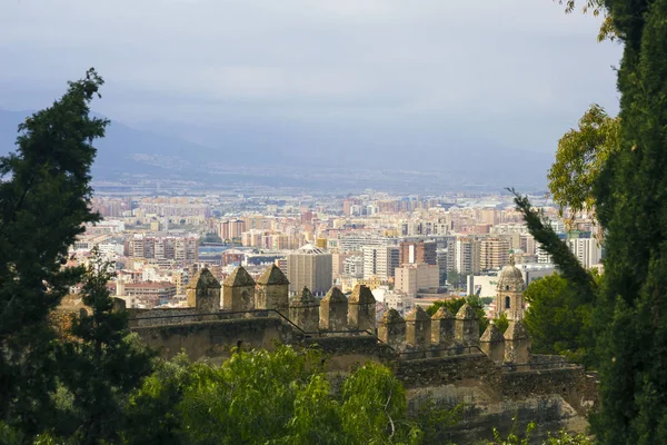 Malaga, Spain, February 2019. Panorama of the Spanish city of Malaga. Buildings, port, bay, ships and mountains against a cloudy sky. Dramatic sky over the city. Beautiful view. — Stock Photo, Image