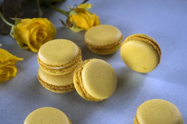 Limon sarısı macaroons Sarı Gül bir arka plan üzerinde. Lezzetli Fransız tatlı. Yakın çekim.