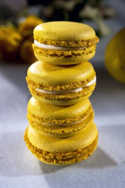 Limon sarısı macaroons Sarı Gül bir arka plan üzerinde. Lezzetli Fransız tatlı. Yakın çekim.