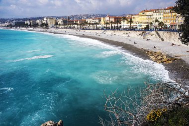 Güzel, Fransa, 2019 Mart. Panorama. Masmavi deniz, dalgalar, İngiliz gezinti ve dinlenme insanlar. Dinlenme ve rahatlama denizin kenarında. Mavi Dalgalar güneşli sıcak günde rulo.