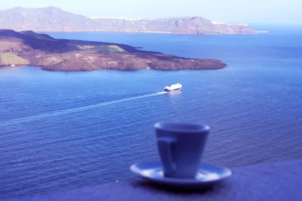 Santorini, Grecja, 2019 kwietnia. Mocna pyszna kawa w białym kubku z talerz na tle morza i pływającej wyściółki. Świetny początek dnia. Przyjemne chwile życia. Podróży. — Zdjęcie stockowe