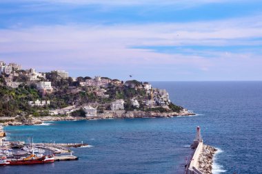 Nice, Fransa, Mart 2019. Fransa'nın Nice şehrinin limanı. Sahile yakın özel yatlar ve tekneler park edilebistir. Güzel dağlar, liman, deniz feneri ve turkuaz deniz - yeniden harika bir yer