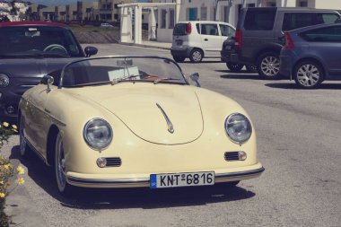 Santorini, Yunanistan, Nisan 2019. Otoparkta retro tarzda küçük bir araba. Arabayla seyahat etmek. Güneşli bir günde kiralık sarı cabrio. Yunan adasında araba kiralama. Renkli.