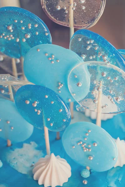 White and blue sweet lollipops decorate a sweet cake for a boy on his birthday. Trendy decor for desserts. Baking for a holiday. — Stock Photo, Image