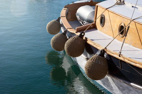 Garde-boue ronds doux, tissés à partir de corde de manila sur un petit vieux navire. Ailes - une partie importante de la configuration du yacht et sert à protéger les côtés. Parking pour bateaux à Cannes, France . — Photo