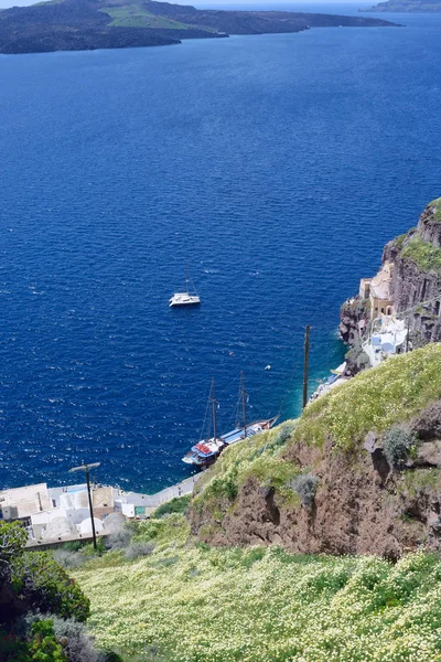 Bella vista sul mare, yacht e montagne coperte di fiori. Isola greca di Santorini in una calda giornata di sole. Viaggia nei luoghi pittoreschi d'Europa. Isole Cicladi nel Mar Egeo . — Foto Stock