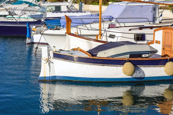 Witte dure jachten op de achtergrond en oude houten boten. Jachtparking in Cannes, Frankrijk. Middellandse Zee. Close-up. — Stockfoto