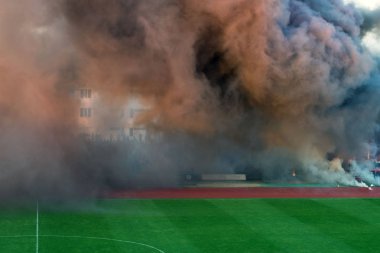 Futbol sahasında kalın dumanın rengi. Futbol hayranları oyun sırasında huzursuzluk yarattı ve renkli duman ile sahada duman bombaları attı. Kamu düzeni ihlali, yaşam tehdidi.