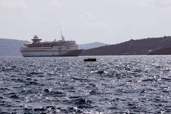 Santorini, Grecja, 2019 kwietnia. Duży biały pasażerski rejs liniowej w starym porcie greckiego miasta Fira. Liner na tle gór i morza w słoneczny dzień. Podróży. Rejsy — Zdjęcie stockowe