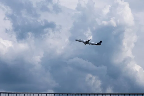 Alemanha, Frankfurt am Main, junho de 2019. Avião no céu entre as nuvens. Uma grande companhia aérea de passageiros branca Lufthansa decola antes de uma tempestade. A viagem começou . — Fotografia de Stock