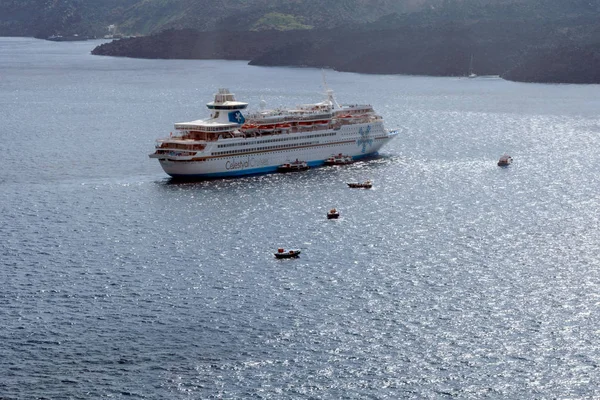 Santorini, Griekenland, april 2019. Grote witte passagiers cruise liner in de oude haven van de Griekse stad Fira. Liner op de achtergrond van bergen en de zee op een zonnige dag. Reizen. Cruises — Stockfoto