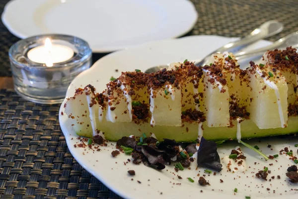 Delicioso plato inusual en un restaurante portugués. Rebanadas jugosas de melón dulce, espolvoreado con chorizo de salchicha de cerdo frito en la parte superior. Sabroso viaje . — Foto de Stock