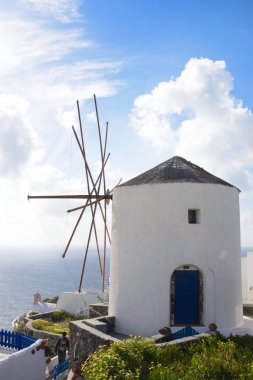 Santorini güzel ada, Yunanistan. Denizin arka planında geleneksel beyaz Yunan evleri ve yel değirmeni. Santorini adasında Oia şehir. Yunan yolculuğu.