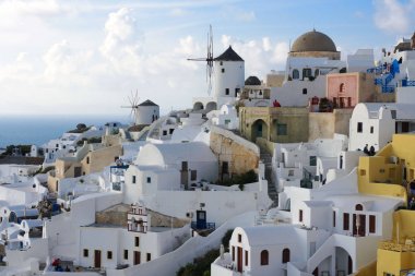 Santorini, Yunanistan, Nisan 2019. Santorini adasında bir yamaç üzerinde Beyaz geleneksel Yunan evleri. Turistler gün batımını bekliyor. Oia şehrinde gün batımı, Santorini.