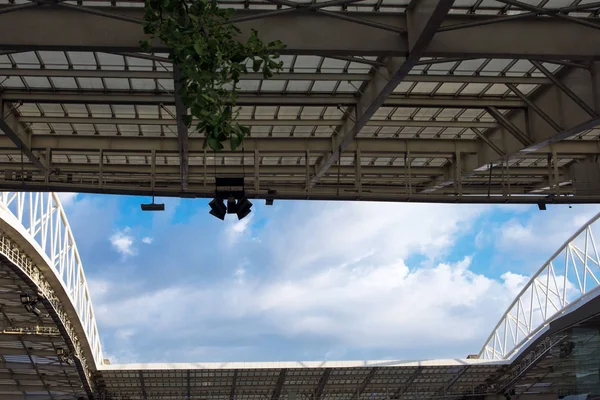 Vita moln på en blå bakgrund är synliga genom byggandet av Dragau Stadium, Porto, Portugal. — Stockfoto
