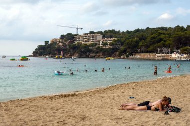 Magaluf, Mallorca, Temmuz 2019. Sabahın erken saatlerinde Mallorca adasında geniş bir kumlu plaj. Denizin, dağların, gökyüzünün ve Magaluf beldesinin otellerinin güzel manzarası. Rahatla. 