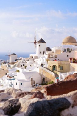 Santorini, Yunanistan, Nisan 2019. Santorini adasında bir yamaç üzerinde Beyaz geleneksel Yunan evleri. Turistler gün batımını bekliyor. Oia şehrinde gün batımı, Santorini.