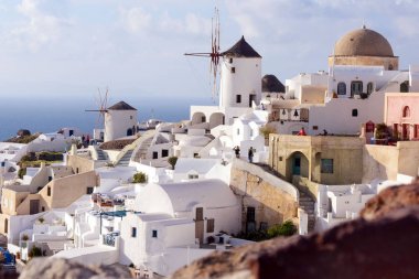 Santorini, Yunanistan, Nisan 2019. Santorini adasında bir yamaç üzerinde Beyaz geleneksel Yunan evleri. Turistler gün batımını bekliyor. Oia şehrinde gün batımı, Santorini.