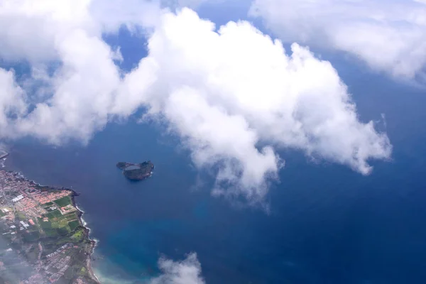 Belle vue sur la mer et la côte de l'île de San Miguel depuis le hublot de l'avion. Nuages blancs au-dessus de l'océan Atlantique. Açores, Portugal . — Photo