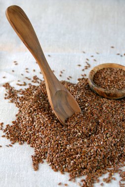 Keten tohumu Linum usitatissimum - yararlı ve tıbbi bir ürün. Close. Keten tohumu arasında doğal zeytin ağacı kaşık ve tabak