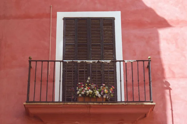 Mercan renk duvarda çiçekler ile metal ferforje balkon. Palm de Mallorca şehrinde geleneksel İspanyol evi, İspanya.