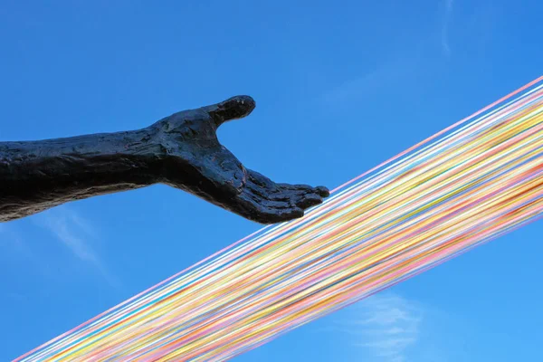 An element of the monument to the first king of Belgium, Leopold the Second in Ostend, is a female sculpture with an outstretched hand against the sky and multi-colored ribbons. Landmark Ostend.