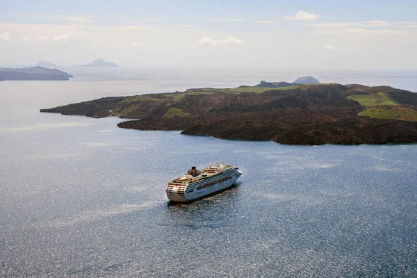 Santorini, Yunanistan, Nisan 2019. Yunanistan'ın Fira kentinin eski limanında büyük beyaz yolcu gemisi. Güneşli bir günde dağların ve denizin arka planında astar. Seyahat. Cruises