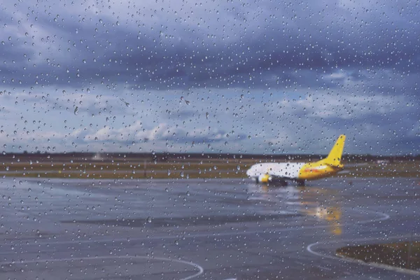 Kiev, Ukraine, septembre 2019. Des gouttes de pluie coulent dans le verre de l'aéroport. Aéroport par temps pluvieux d'automne. Seul avion DHL Express. La livraison des marchandises et du courrier a lieu par tous les temps . — Photo
