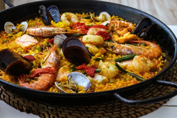  Siyah bir tavada geleneksel İspanyol deniz ürünleri paella çanak. Midye, Amandi ve karidesler pirinç yastığının üzerinde. Close. Mallorca adasında bir İspanyol restoranında lezzetli sağlıklı akşam yemeği.