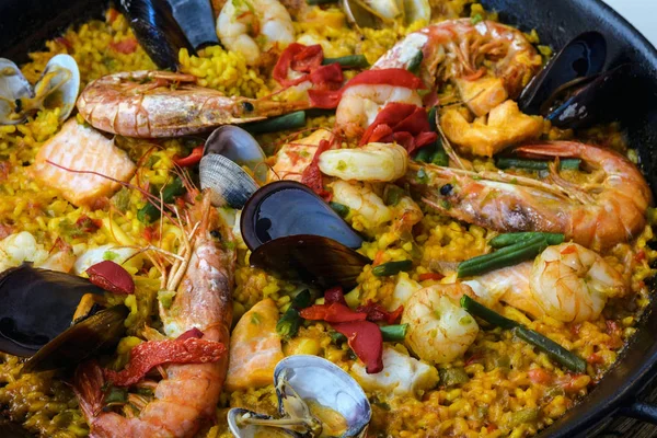      Siyah bir tavada geleneksel İspanyol deniz ürünleri paella çanak. Midye, Amandi ve karidesler pirinç yastığının üzerinde. Close. Mallorca adasında bir İspanyol restoranında lezzetli sağlıklı akşam yemeği.