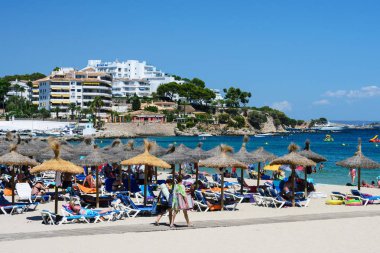 Palma Nova, Mallorca, Temmuz 2019. Sabahın erken saatlerinde Mallorca adasında geniş kumlu bir sahil. Deniz manzarası, gökyüzü ve turistler. Rahat ol. Balear Adaları.