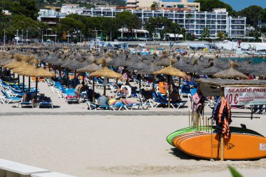 Palma Nova, Mallorca, Temmuz 2019. Sabahın erken saatlerinde Mallorca adasında geniş kumlu bir sahil. Palma Nova tatil beldesinde çok renkli sörf tahtaları. Rahat ol. Balear Adaları.