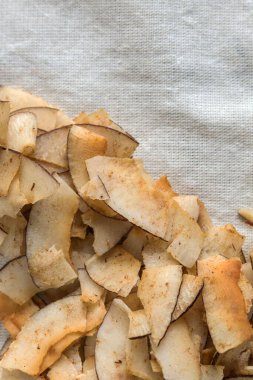 Lezzetli hindistan cevizi cipsleri ve beyaz bir bez parçasında tuzlanmış karamel. Hindistan cevizi hamurundan yapılan doğal ürün. Atıştırmak için faydalı bir atıştırmalık. Düzgün beslenme kavramı.