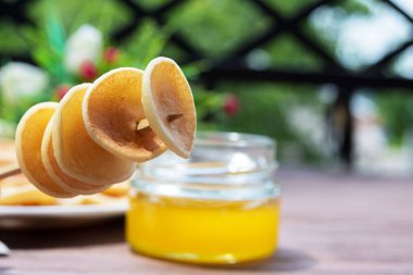 Mısır gevreği mini krepleri. Çubukta Amerikan gözlemeleri ve eski ahşap bir masada bal. Lezzetli geleneksel Amerikan kahvaltısı. Yukarıdan bak. Yakın plan..