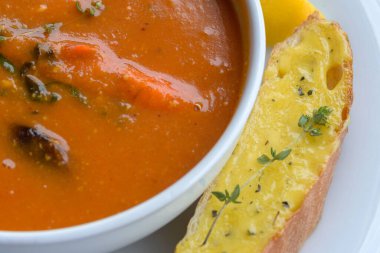 Kızarmış ve biberiyeli, beyaz tabakta balık çorbası. Geleneksel Fransız mutfağından bir tabak. Yakın çekim, yumuşak odaklanma.