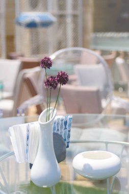 Şeffaf plastik sandalyeler ve mavi denizin arka planında bir masa. Deniz kenarındaki bir restoranda yemek hazırlıyorum..