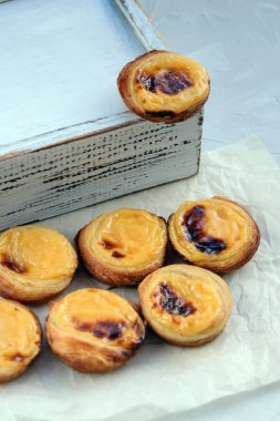 Geleneksel Portekiz popüler tatlı Pastel de nata veya Pastel de Belem. Lezzetli muhallebi fincanları ve muhallebi. Dikey yönelim.