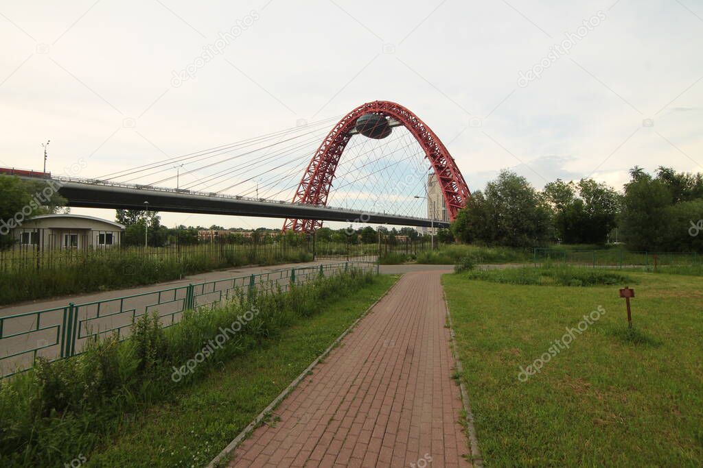 Architectural building across the Moscow River, red bridge in the form of a spider